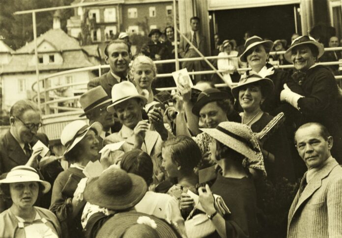 Jan Kiepura rozdaje autografy swym wielbicielom zebranym przed hotelem Patria, rok 1935 © Narodowe Archiwum Cyfrowe
